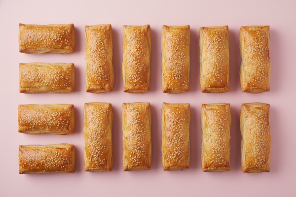 12 RECTANGLE PUFF PASTRIES WITH SESSAME SEEDS ON TOP AND #C85393 BACKGROUND