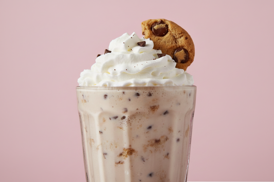 CHOC CHIP COOKIE SHAKE WITH SMALL PIECE OF COOKIE ON THE WHIP CREAM AS GARNISH IN A MILKSHAKE GLASS WITH THE BACKGROUND BEEN #c85393